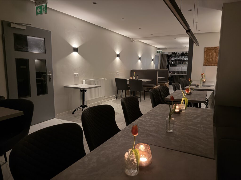 Gemütlicher Sitzbereich im Hansefrisch Restaurant mit modernen Tischen und warmem Ambiente.